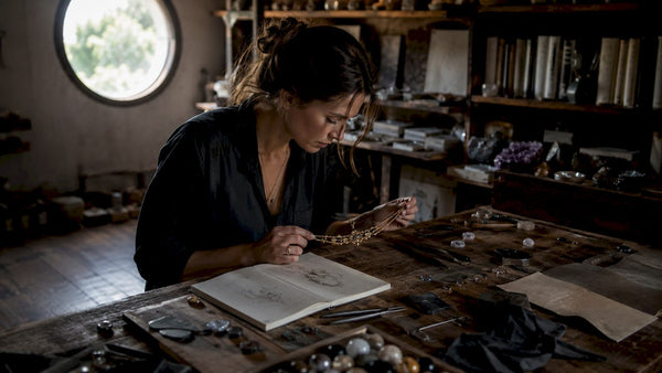 Jewelry designer reviewing timeless necklace in studio