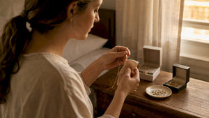 Hands cleaning fine gold necklace at home