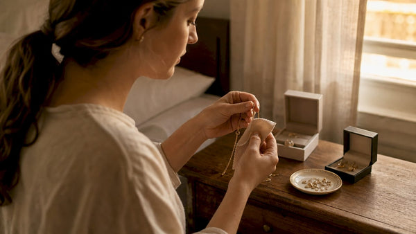 Hands cleaning fine gold necklace at home