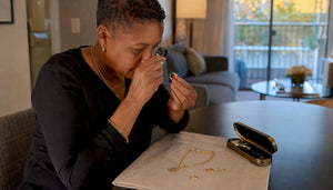 Woman closely inspecting jewelry stamp