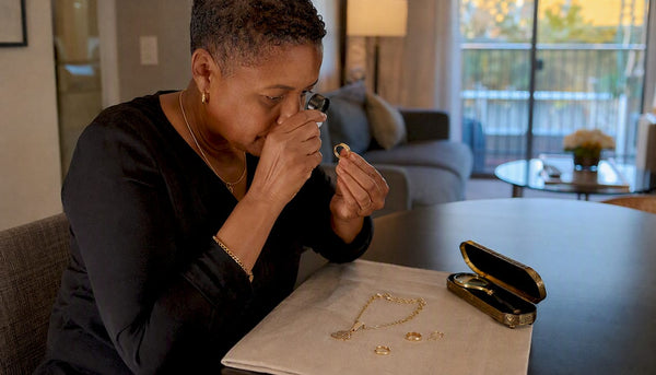 Woman closely inspecting jewelry stamp