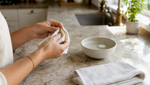 Hands cleaning gold chain with cloth